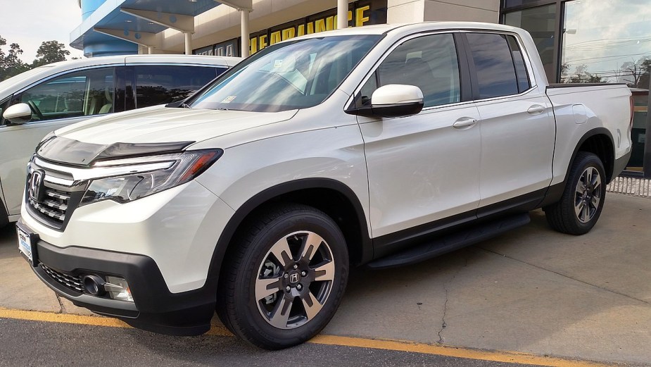A 2017 Honda Ridgeline in white sits at a dealership.