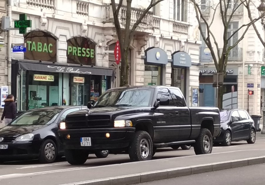 A 2018 Ram 1500 in black drives on the road.