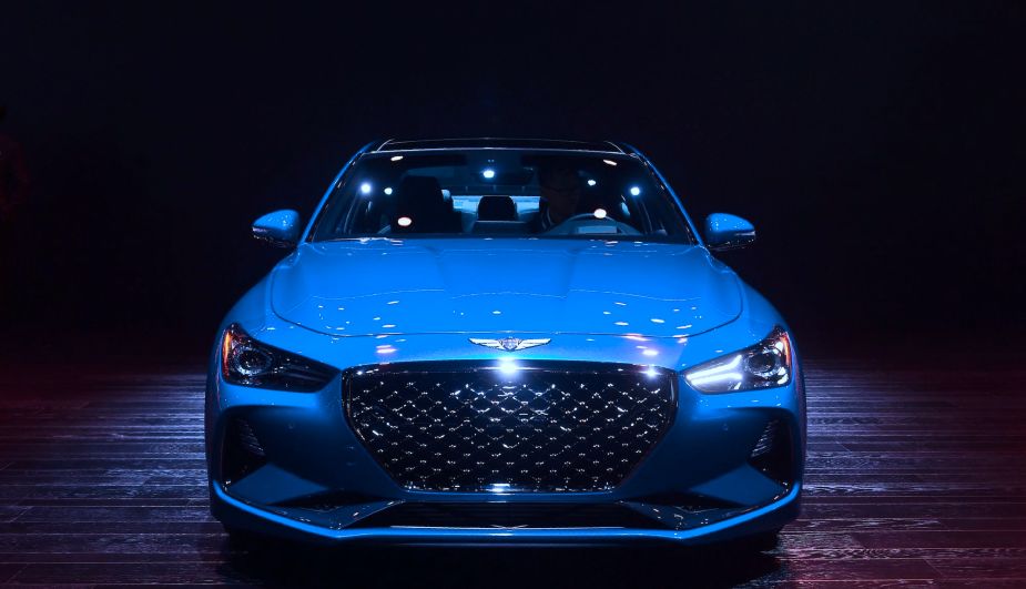 A blue 2019 Genesis G70 in a dark lit room.