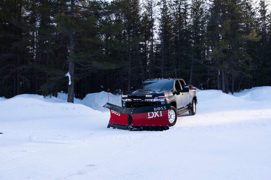 Promo of a black, heavy-duty Chevy pickup truck plowing snow.