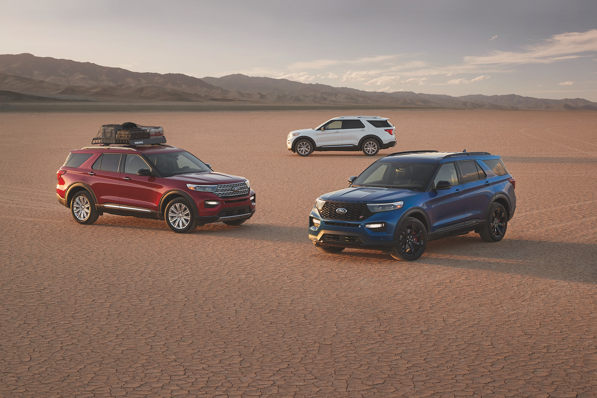 Three different 2022 Ford Explorers parked in a desert area.