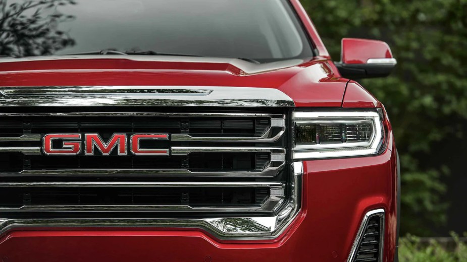 A red 2022 GMC Acadia close up on the headlight and front grille. Is it worth the money for the luxury Denali trim?