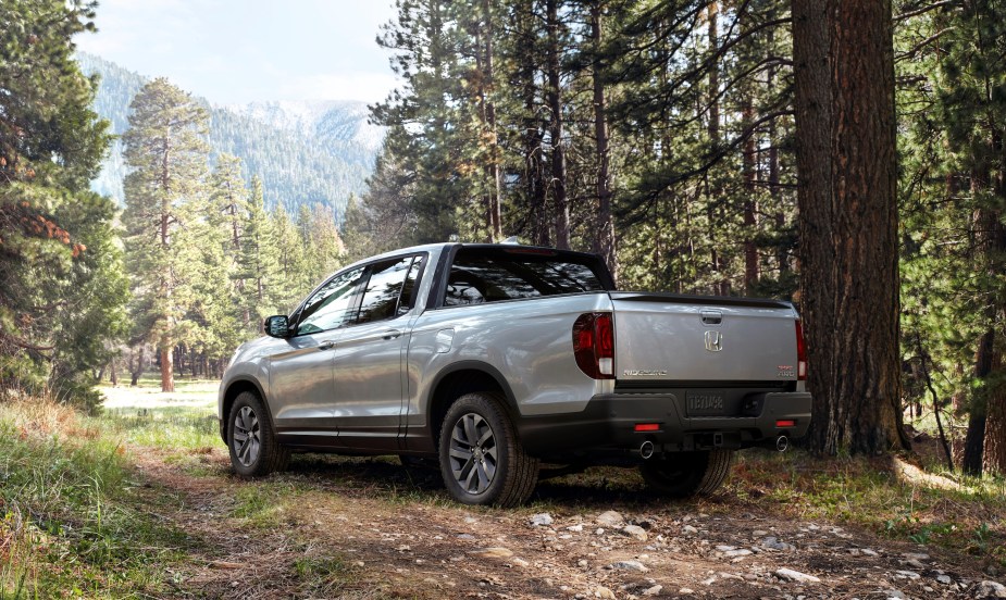 A silver 2022 Honda Ridgeline midsize pickup truck parked in the woods. What makes it the best tailgating truck during football season?