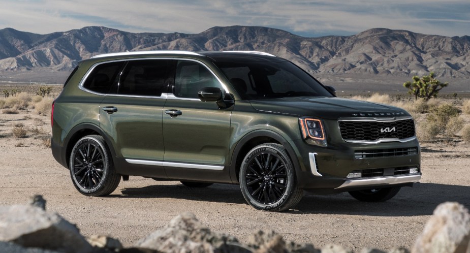 A green 2022 Kia Telluride midsize SUV is parked off-road. 