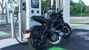 The rear 3/4 view of a black 2022 LiveWire One at an Electrify America charging station