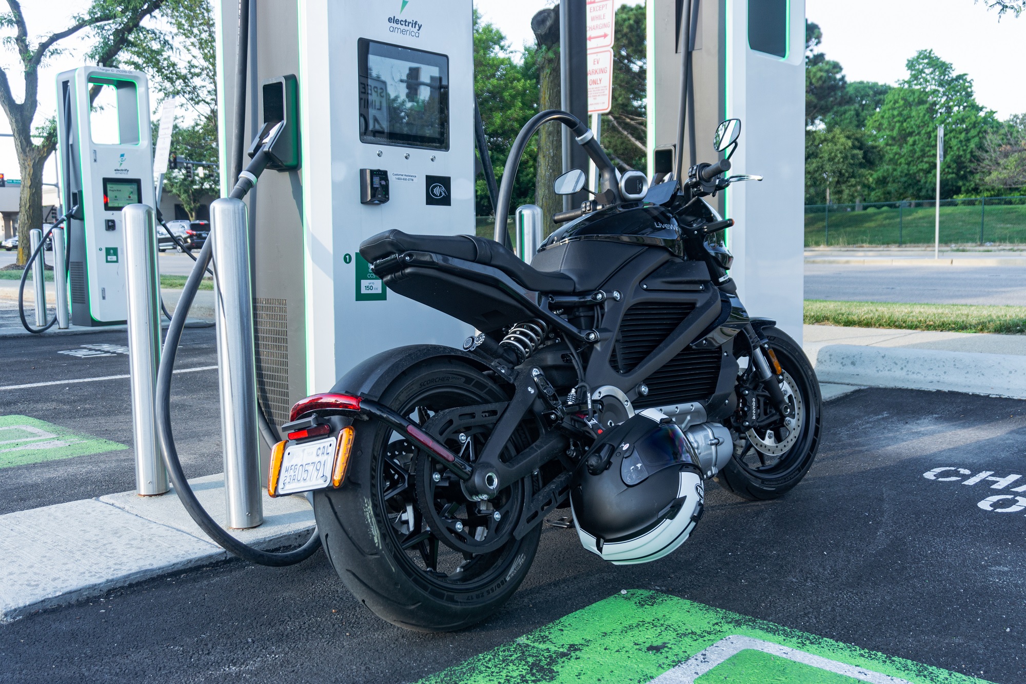 The rear 3/4 view of a black 2022 LiveWire One at an Electrify America charging station