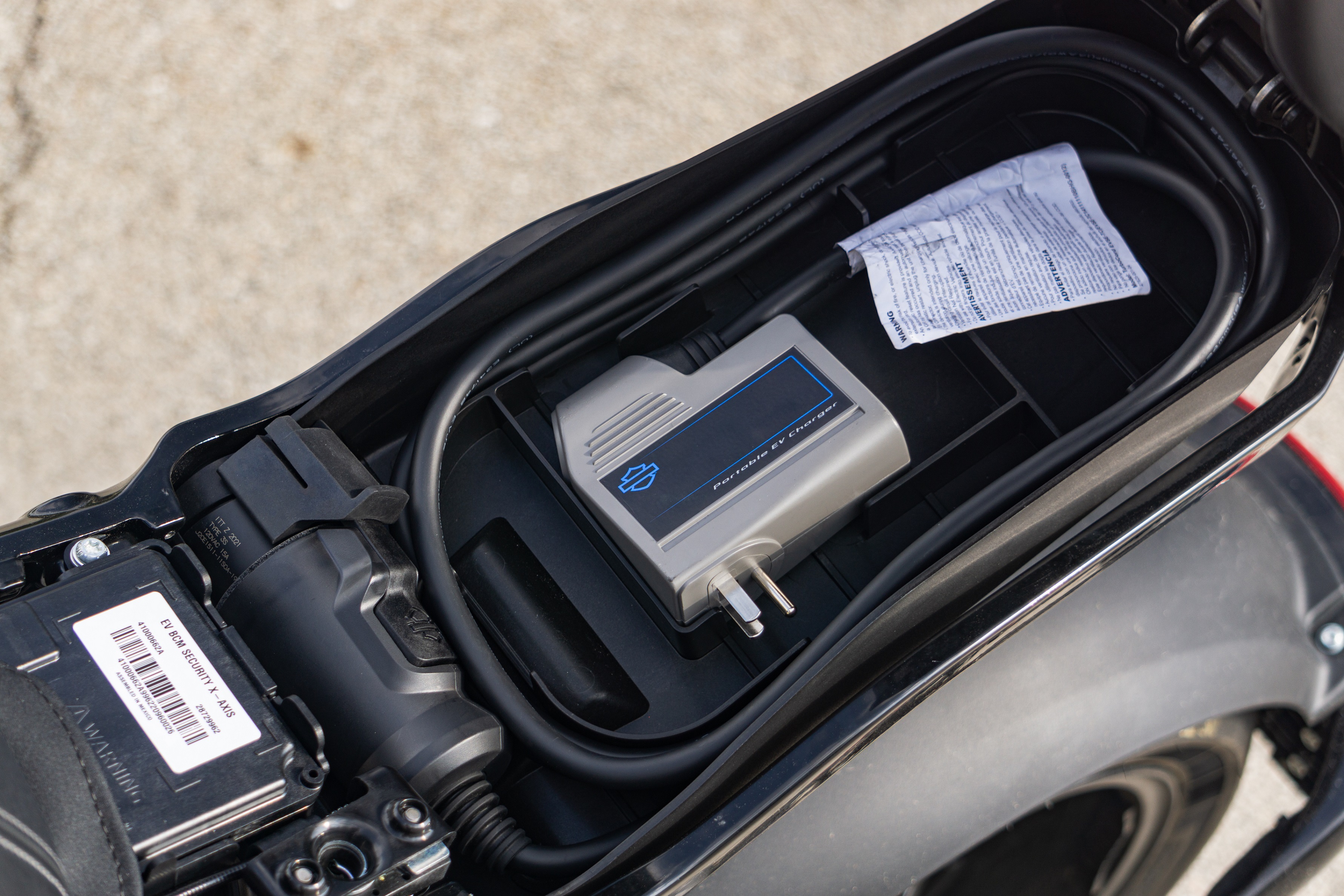 The charger cord for a 2022 LiveWire One in its under-seat storage space