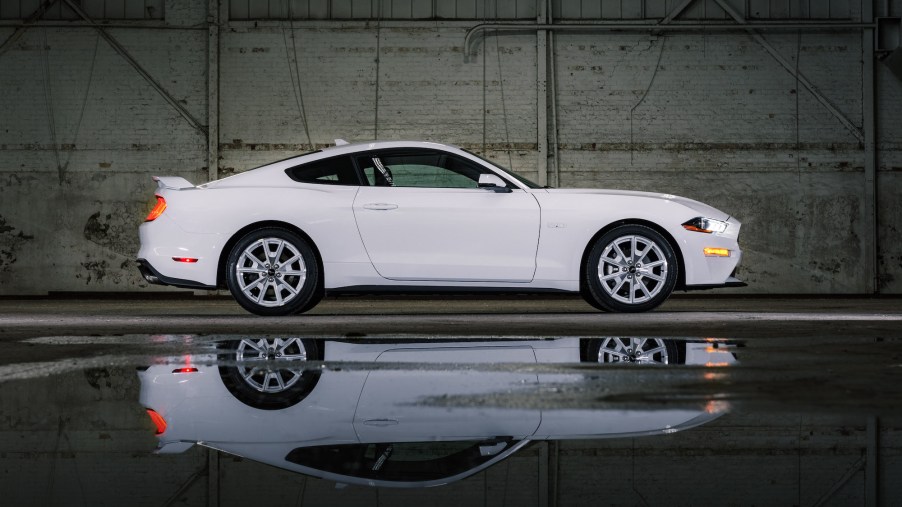 A white 2022 Ford Mustang parked in a warehouse