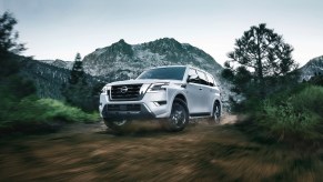 A white 2022 Nissan Armada SUV driving in the mountains