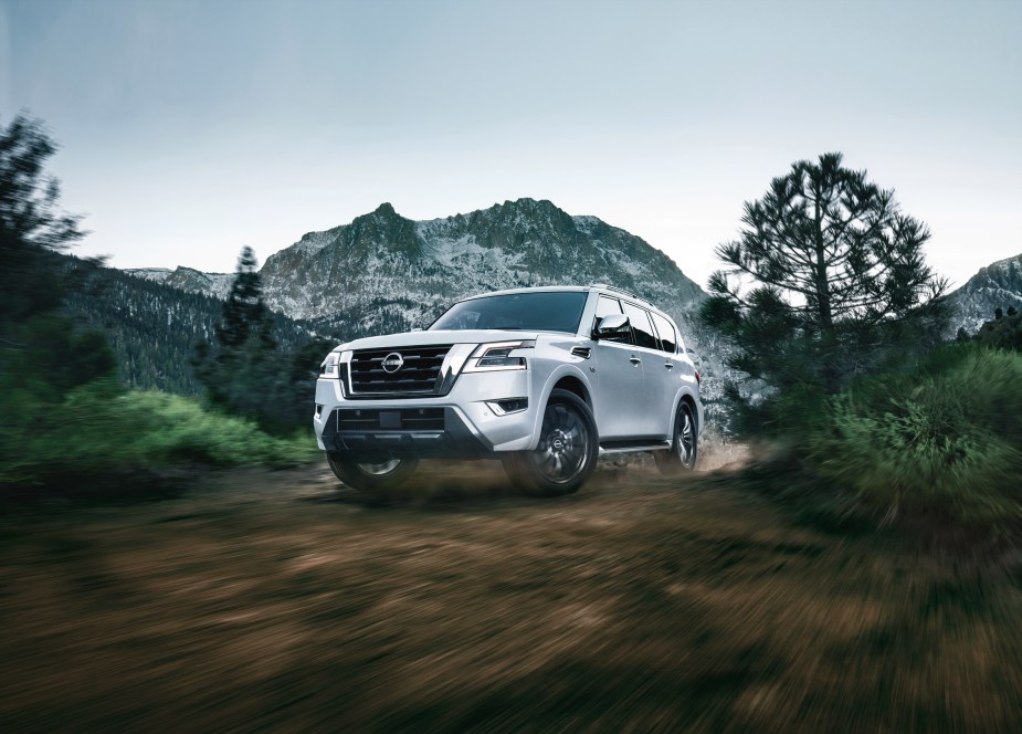 A white 2022 Nissan Armada SUV driving in the mountains. The best trim is the most popular for the SUV. 