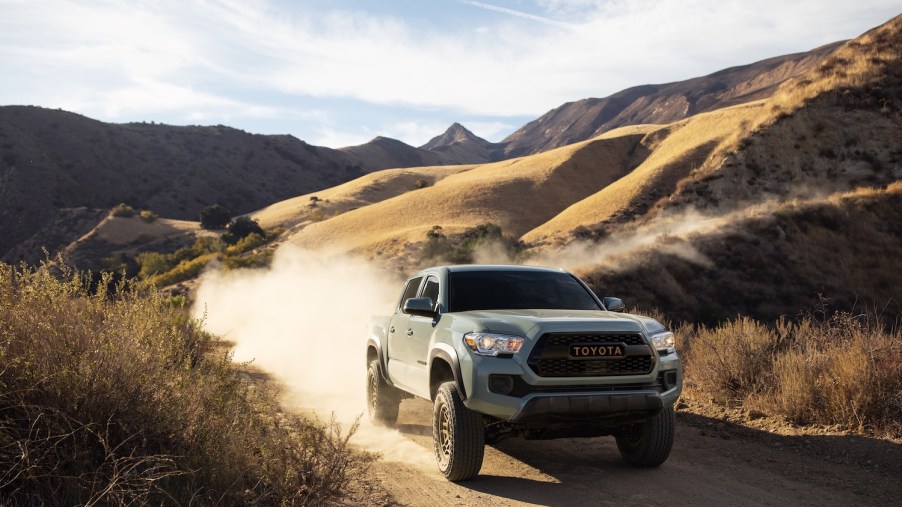 A 2022 Toyota Tacoma midsize truck driving in the dirt
