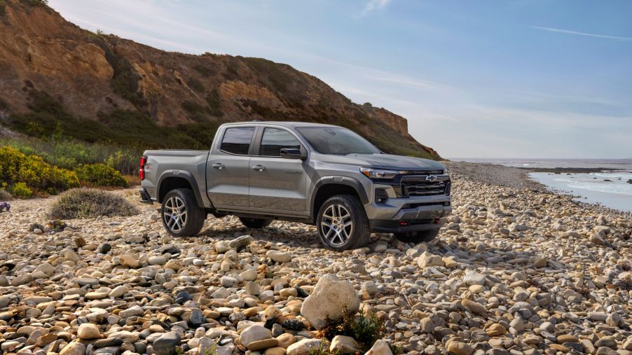 A 2023 Chevrolet Colorado Z71 midsize pickup truck parked on a beachfront covered in rocks