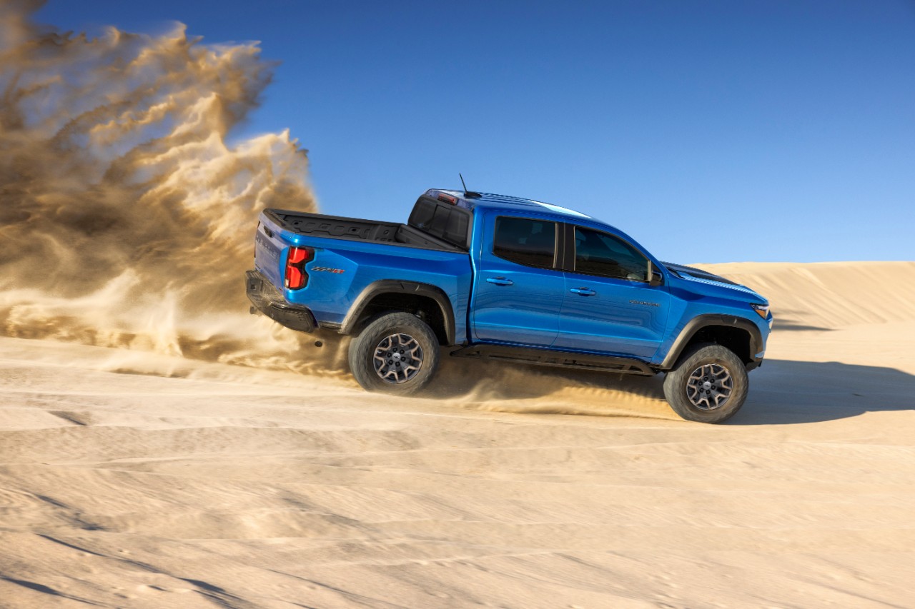 2023 Chevrolet Colorado ZR2 riding on sand, with a blue sky in the background