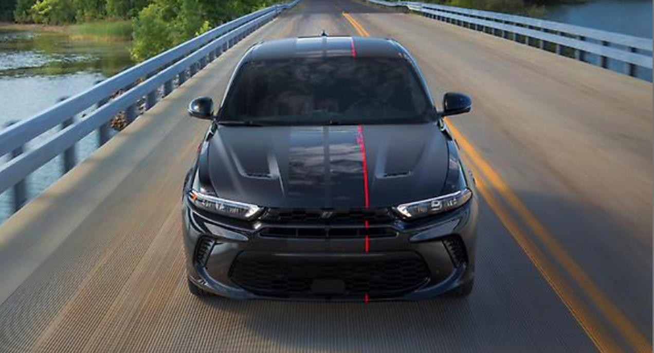 A black 2023 Dodge Hornet is driving on the road.
