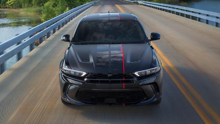 A black 2023 Dodge Hornet is driving on the road.