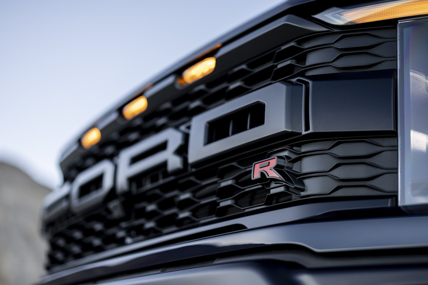 The grille of a Ford Raptor R pickup truck with amber marker lights for clearance reasons.