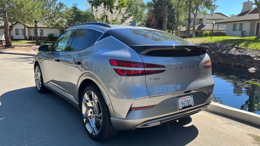 A rear view of the 2023 Genesis GV60 next to a pond.
