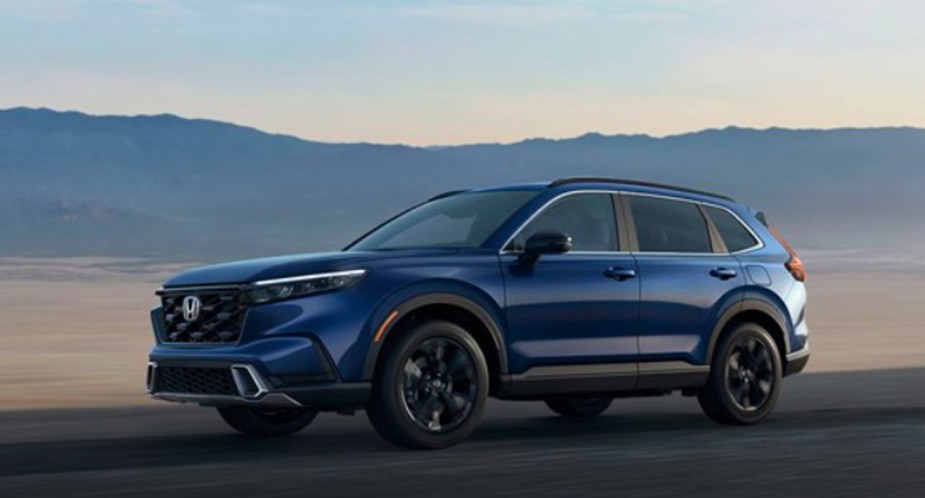 A blue 2023 Honda CR-V small SUV is driving on the road.
