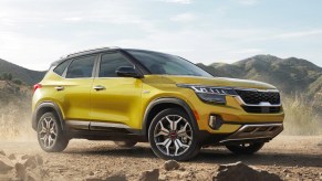 A yellow 2023 Kia Seltos subcompact SUV is parked outdoors.