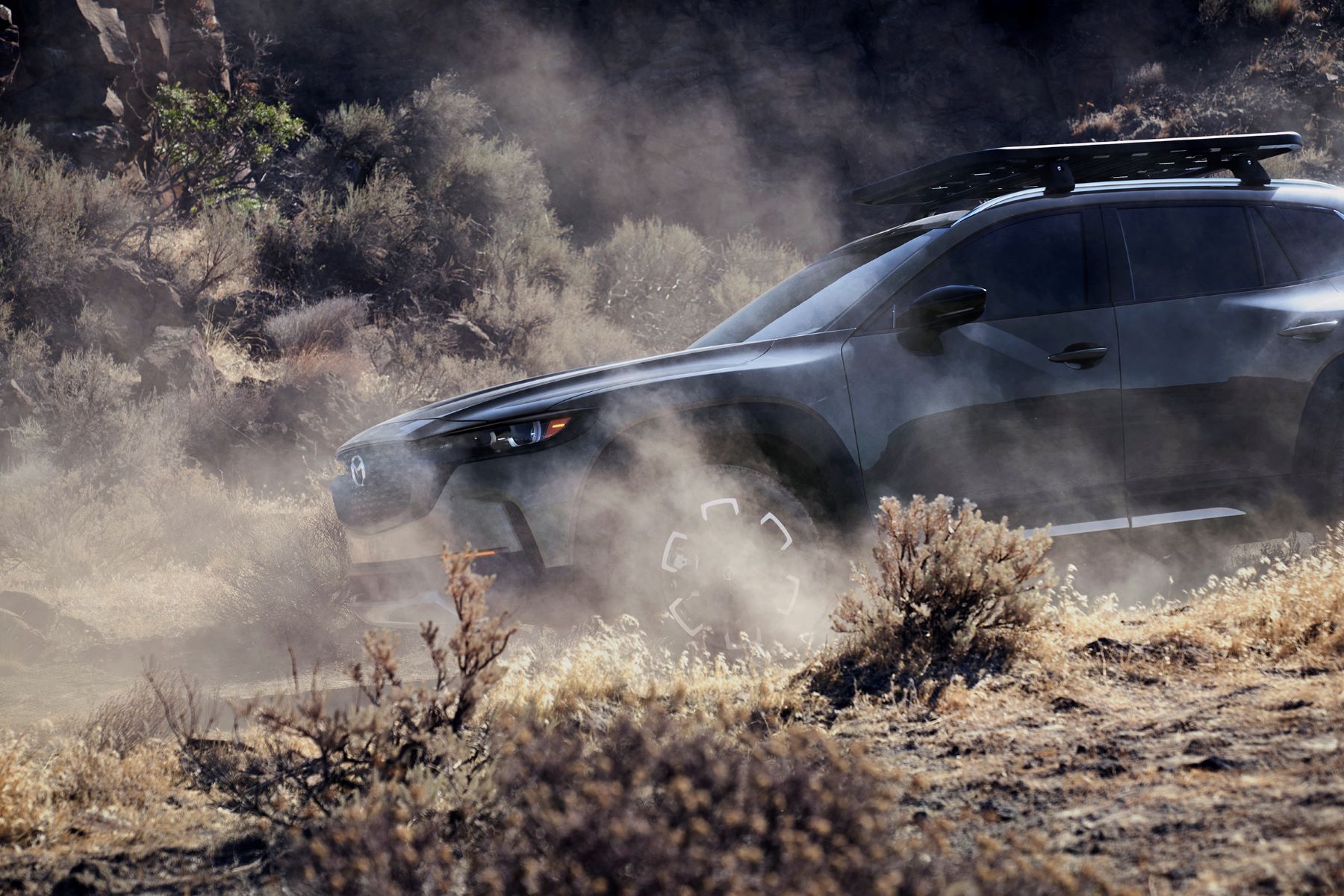 A 2023 Mazda CX-50 covered in desert dust from driving on an off-road trail