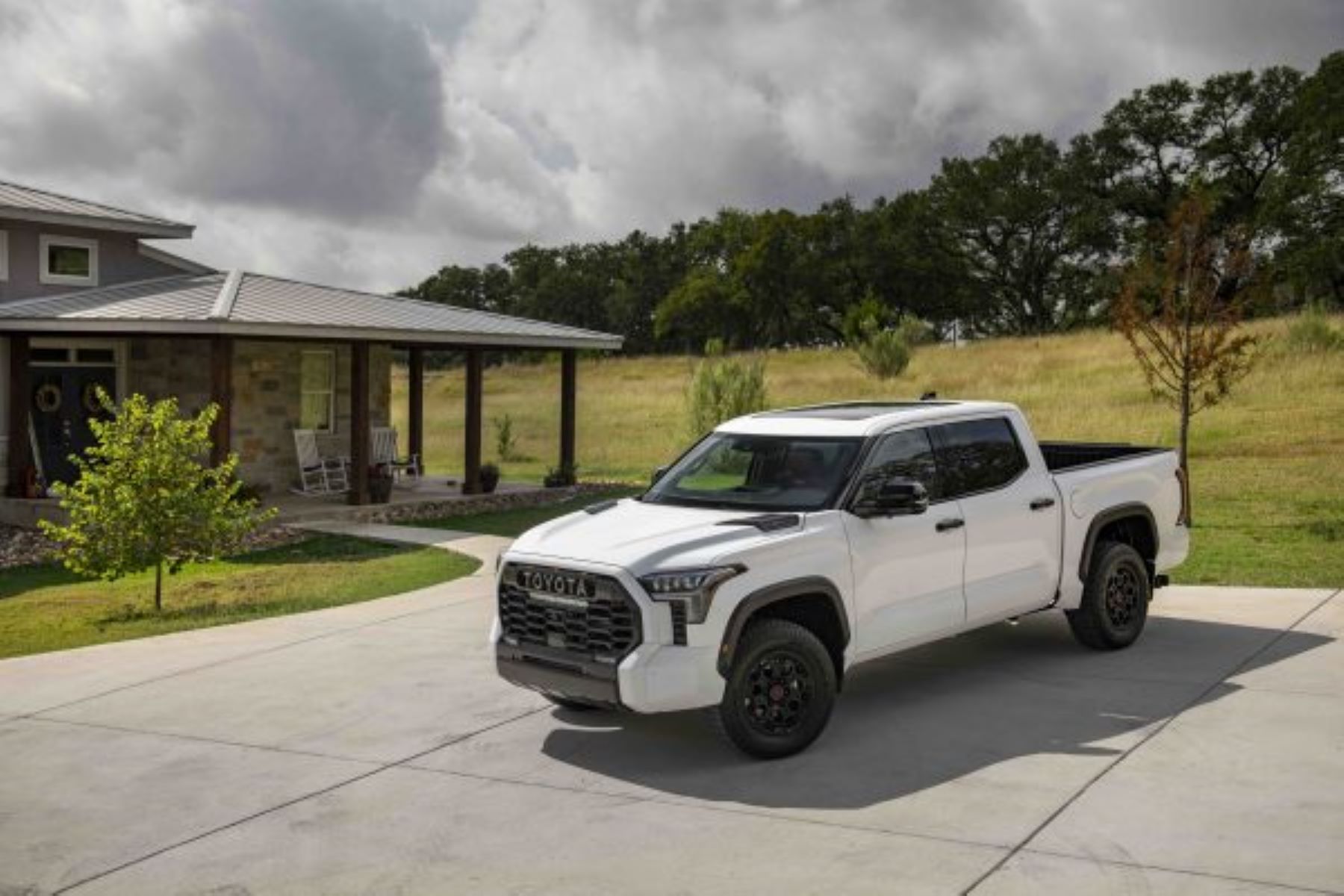 A 2023 Toyota Tundra TRD Pro full-size pickup truck in Super White parked outside a country rural home