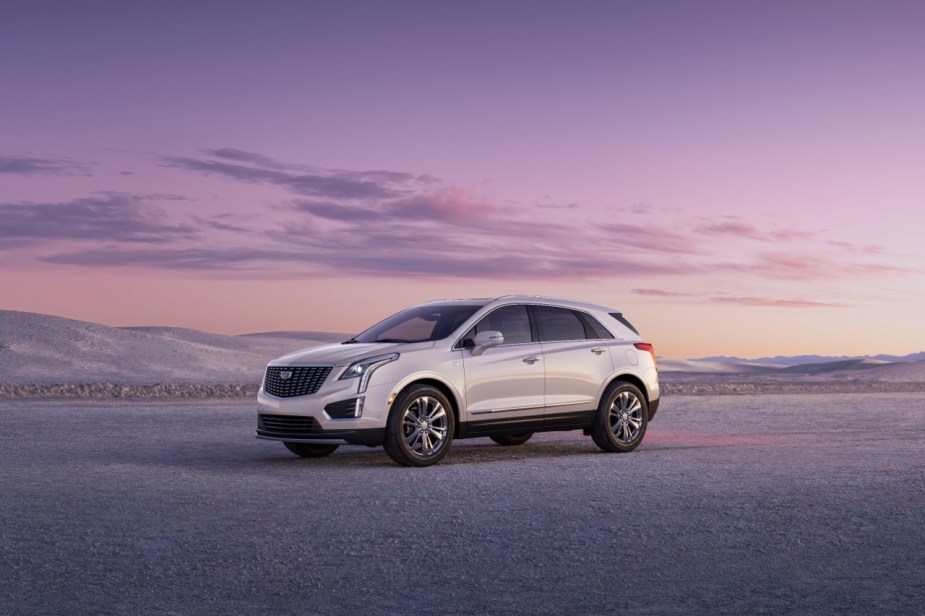 A white 2023 Cadillac XT5 sitting on a flat plain with a purple sky in the background.