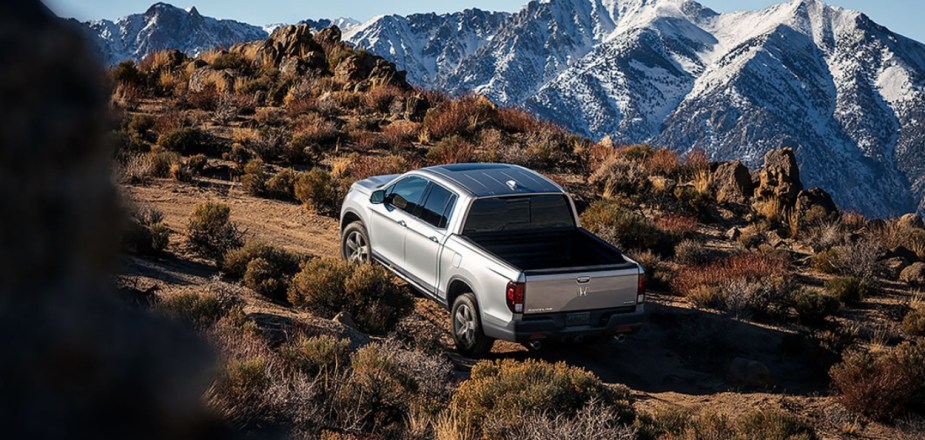 A 2023 Honda Ridgeline mid-size truck drives on a remote trail.