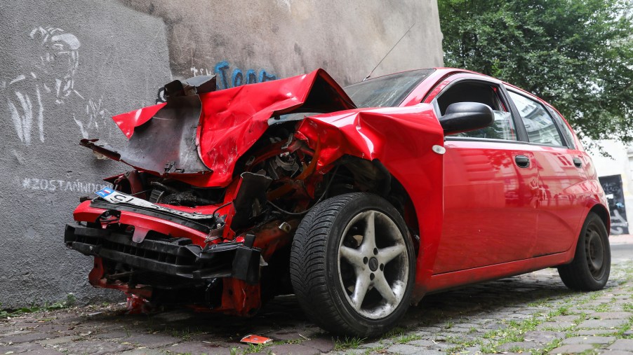 A picture of a red car photographed after an accident.