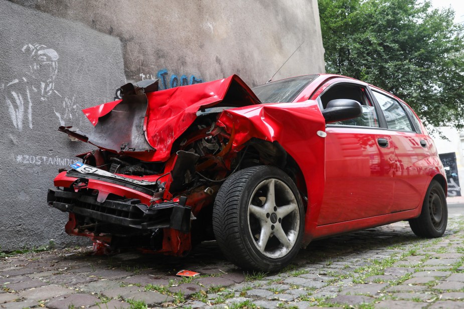 A picture of a red car photographed after an accident. 