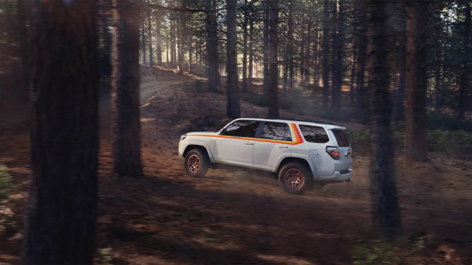 A white 2023 Toyota 4Runner Anniversary Edition driving up a hill.