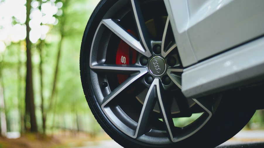 A close up photo of a car tire with red brake calipers