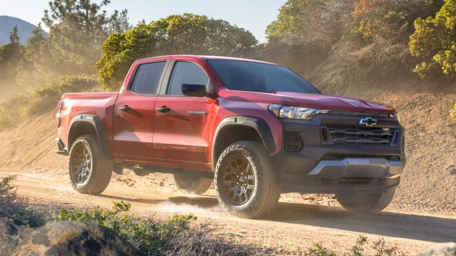 Cherry Red Tintcoat 2023 Chevy Colorado driving on a dirt road