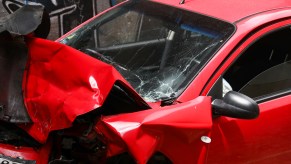 A red car accident photo with front damage.