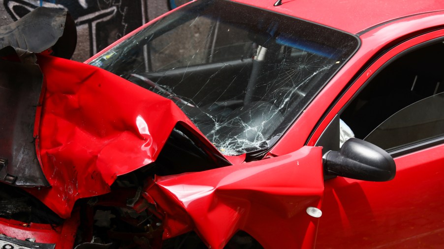 A red car accident photo with front damage.