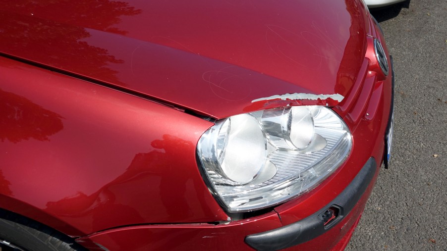 A red damaged car potentially with cheap insurance.