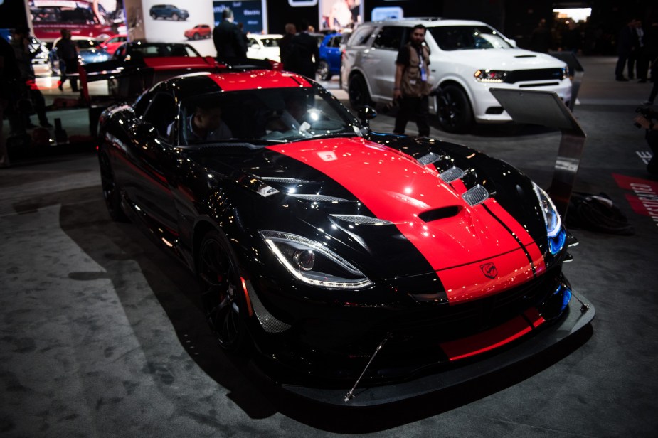 A black Dodge Viper with a red stripe down the center parked indoors. 