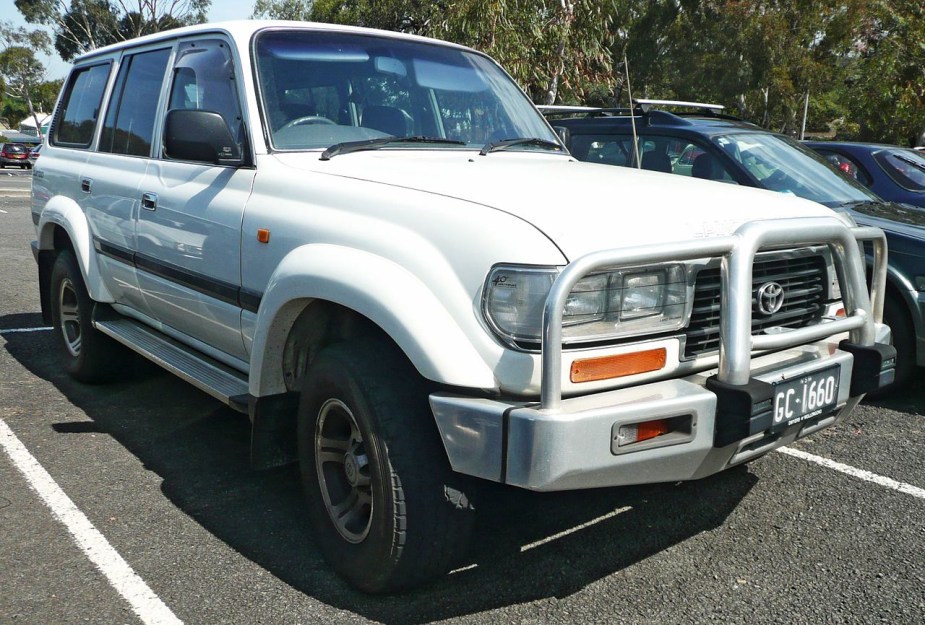 An 80 Series Toyota Land Cruiser in white sits in a parking lot.