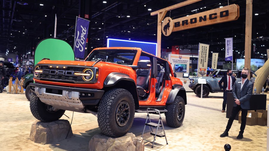 Potentially an orange Ford Bronco Raptor set indoors in an imitated outdoor scene.