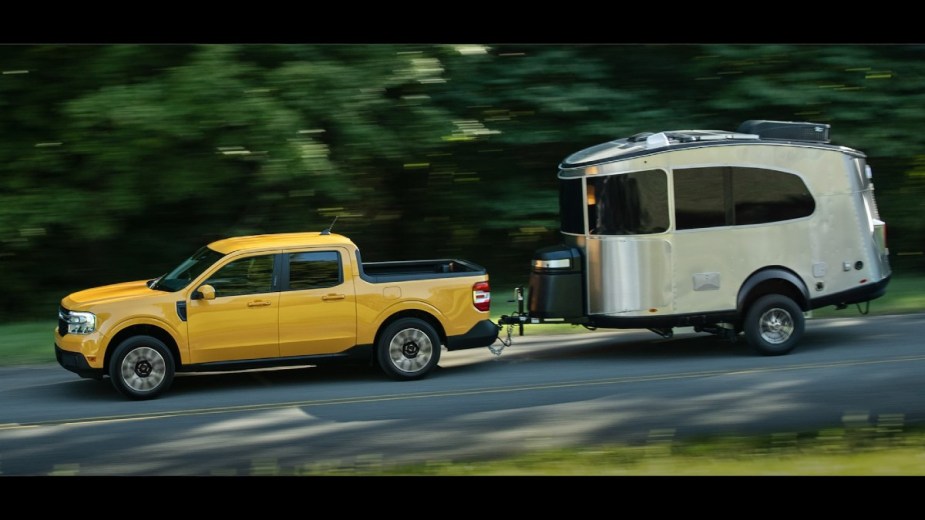 Yellow Ford Maverick towing a travel trailer