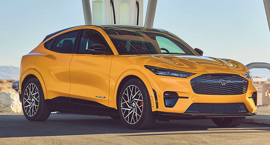 A yellow Ford Mustang Mach-E electric SUV is parked.