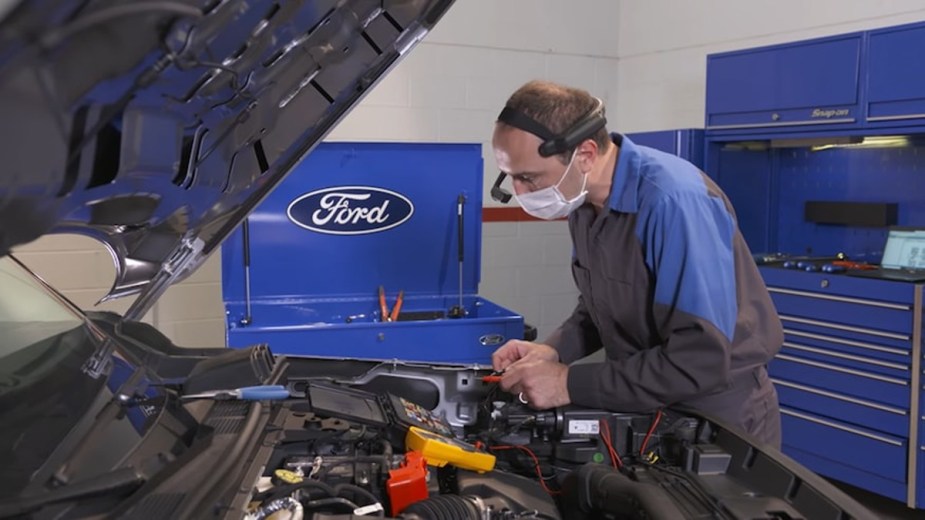 Ford Technician Working on a Vehicle Wearing the SWIS Headset