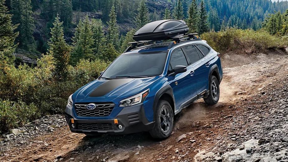 Geyser Blue 2023 Subaru Outback crossover SUV driving down a hill