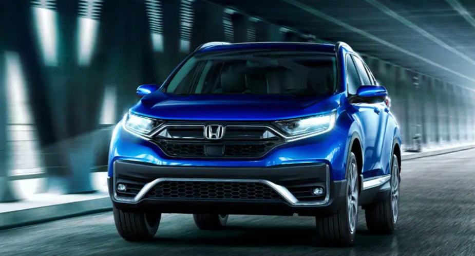 A blue 2022 Honda CR-V Hybrid small SUV is driving. 