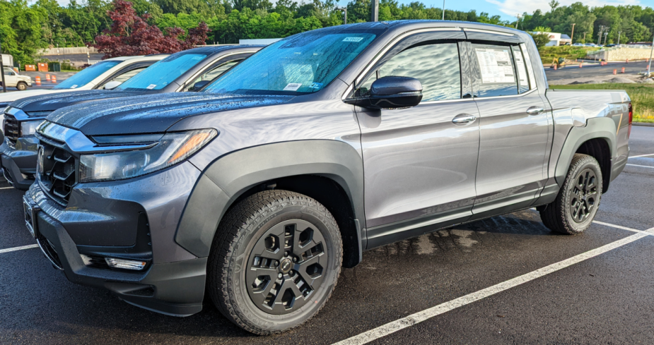 A grey 2023 Honda Ridgeline with HPD package sits in a parking lot. 