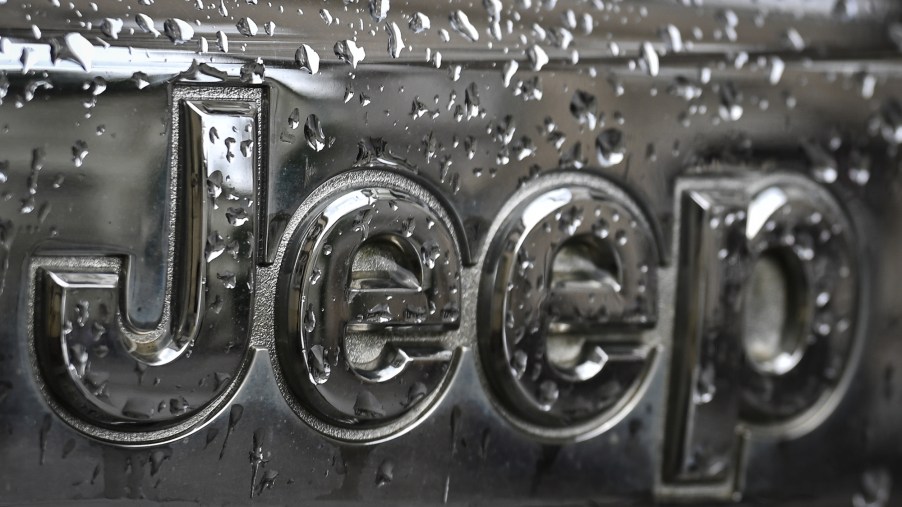 A silver Jeep logo covered in water, maker of the Jeep Wrangler.