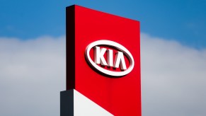 A Kia logo on a red sign.