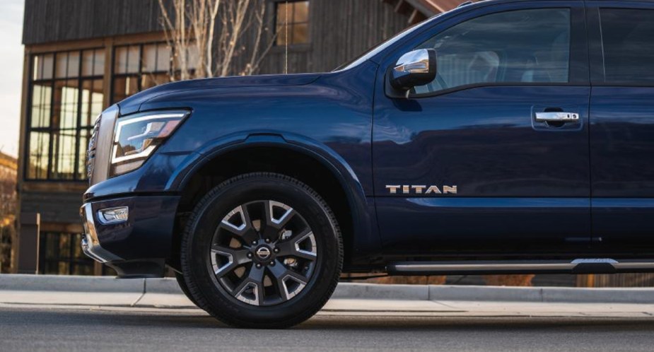 A blue Nissan Titan full-size pickup truck is parked. 