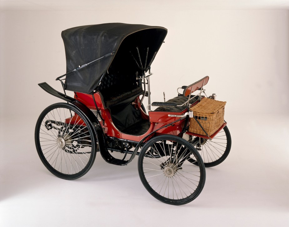 A red horseless carriage built by Peugeot.