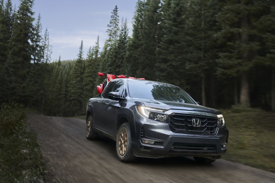 As a mid-size truck, the Honda Ridgeline carries some dirtbikes on a remote road.