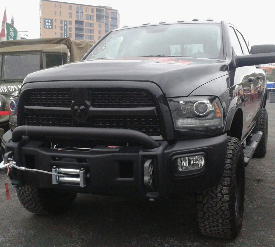 A lifted 2013 Ram 1500 sits in a parking lot.